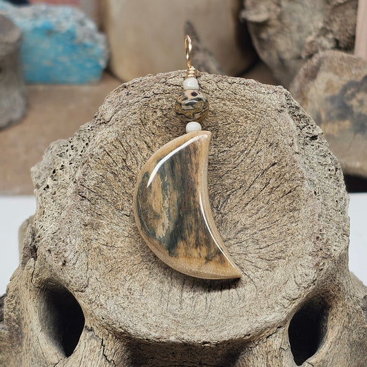 Front view of a mammoth fossil ivory crescent moon pendant with leopard-skin jasper, crafted by Kristin R Park at Ice Age Treasures.