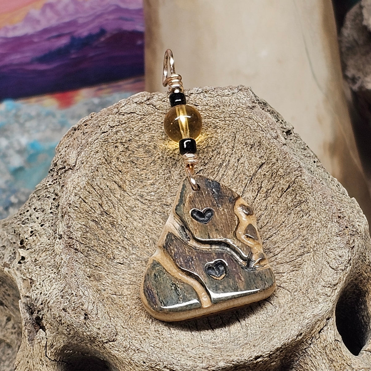 Heart Totem mammoth fossil ivory pendant showing carved hearts and cream and dark greens and browns mineralization, crafted by Kristin R Park at Ice Age Treasures.