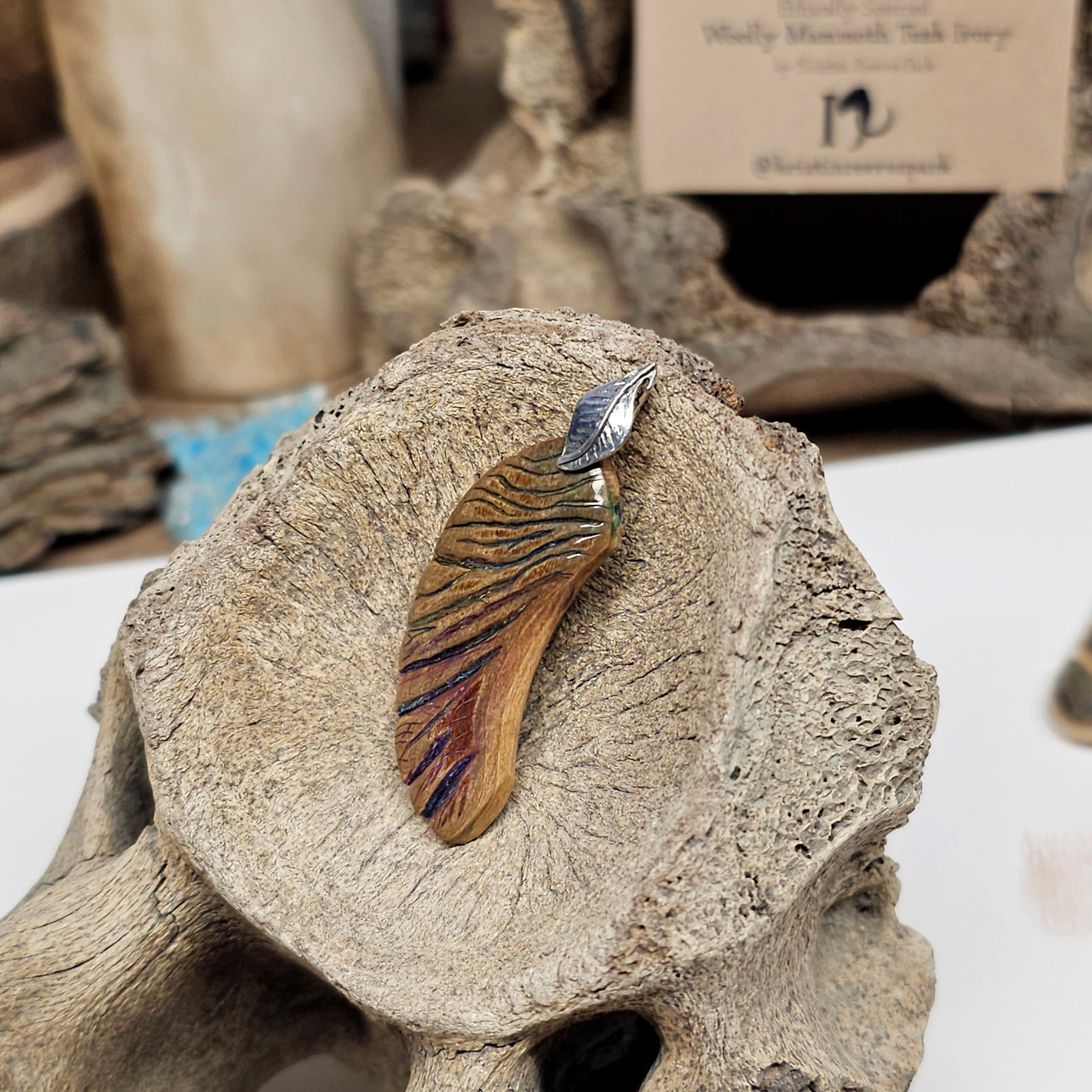 Scrimshaw-style needle etching detail in purples, pinks and greens on Woolly Mammoth fossil ivory pendant crafted by Kristin at Ice Age Treasures
